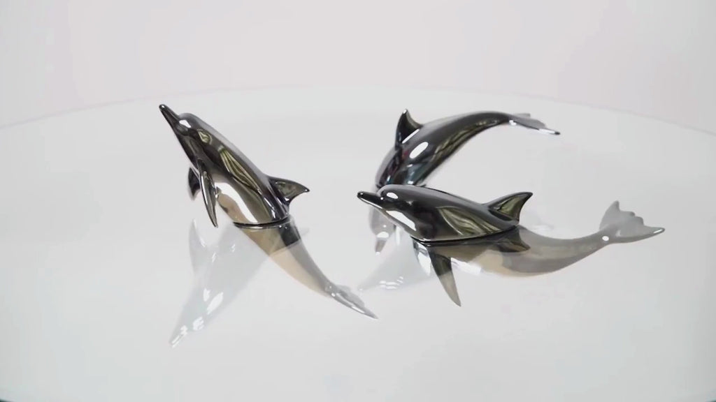 Harmony Dolphin Set by Waterines — 3D sculpted magnetic resin dolphin sculptures swim across a glass coffee table.