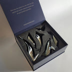 Harmony Dolphin Set by Waterines — 3D sculpted magnetic resin dolphin sculptures swim across a glass coffee table.