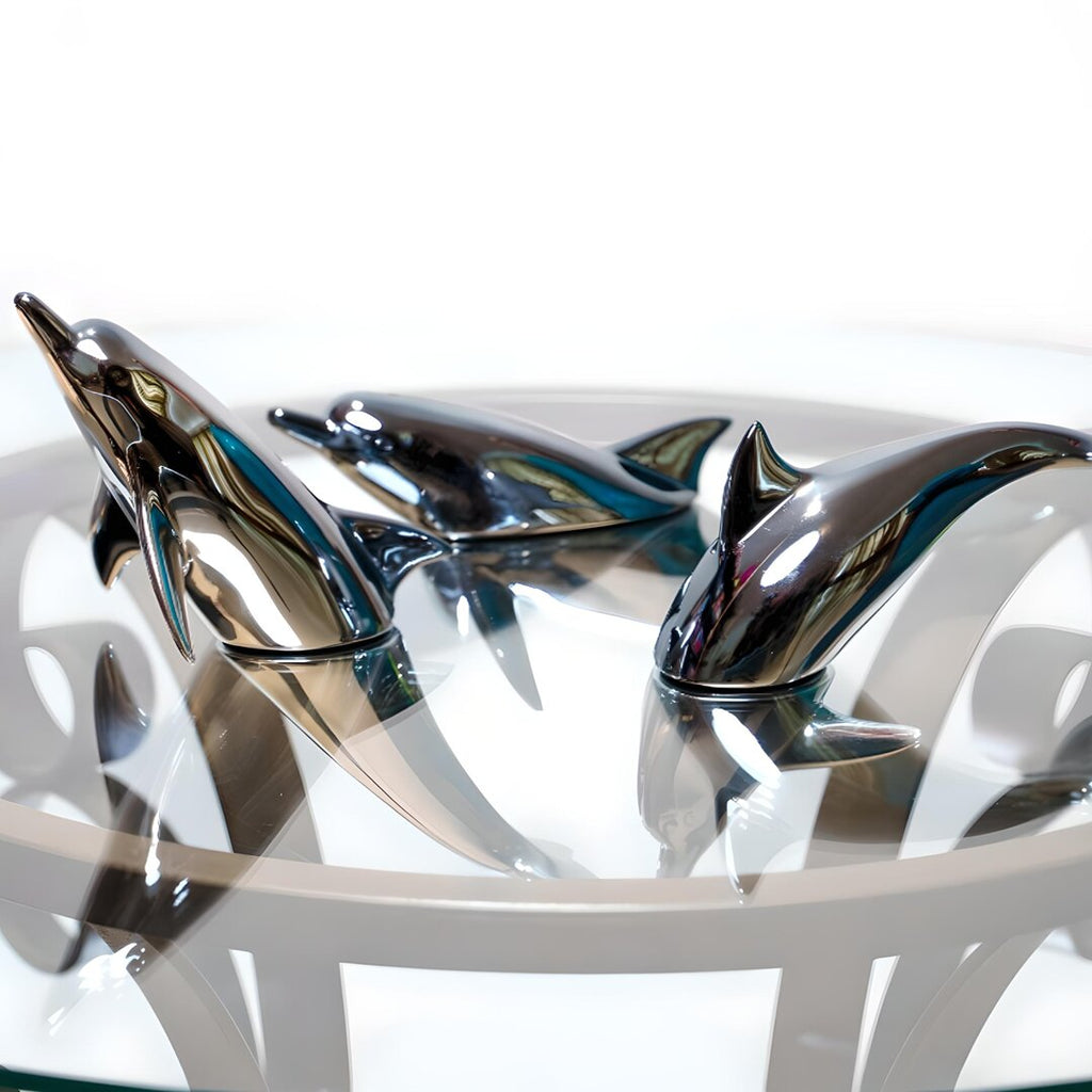 Harmony Dolphin Set by Waterines — 3D sculpted magnetic resin dolphin sculptures swim across a glass coffee table.