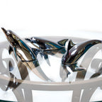 Harmony Dolphin Set by Waterines — 3D sculpted magnetic resin dolphin sculptures swim across a glass coffee table.