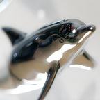 Harmony Dolphin Set by Waterines — 3D sculpted magnetic resin dolphin sculptures swim across a glass coffee table.