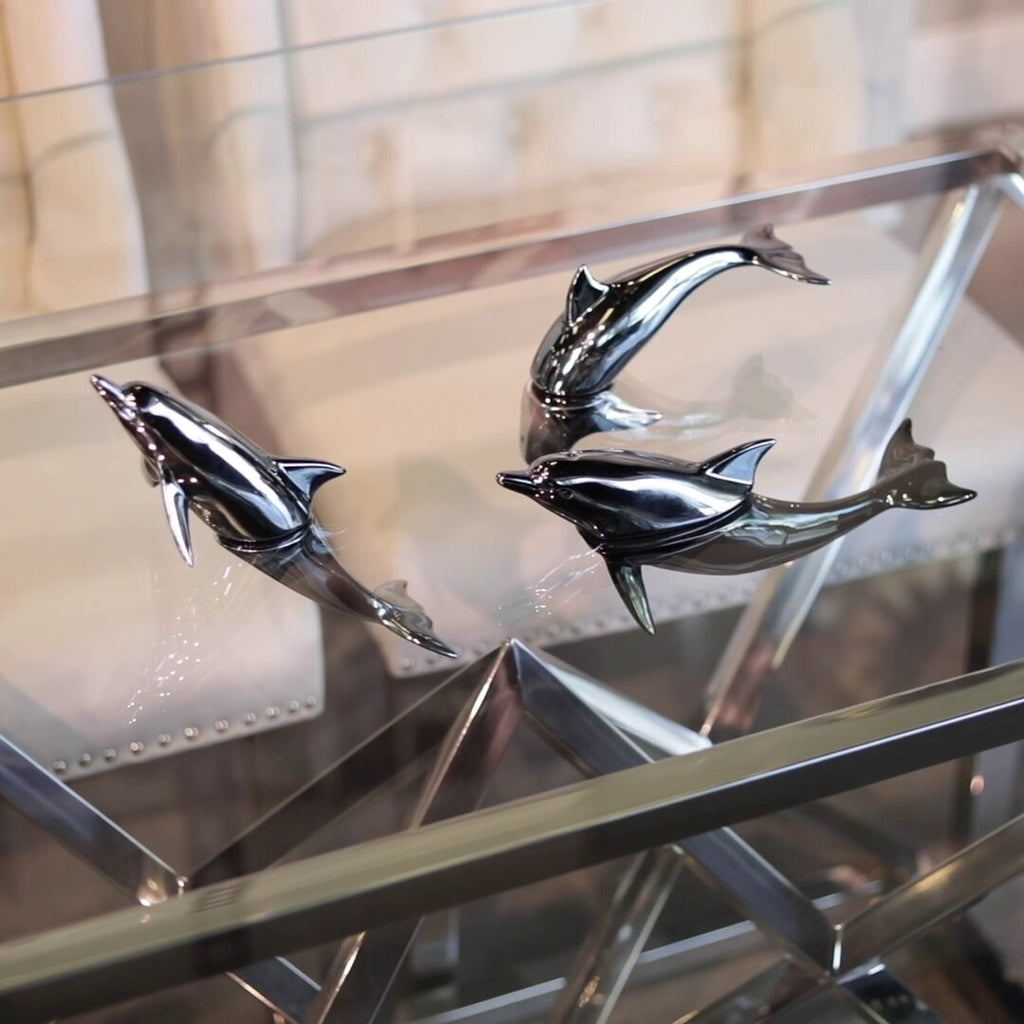 Harmony Dolphin Set by Waterines — 3D sculpted magnetic resin dolphin sculptures swim across a glass coffee table.