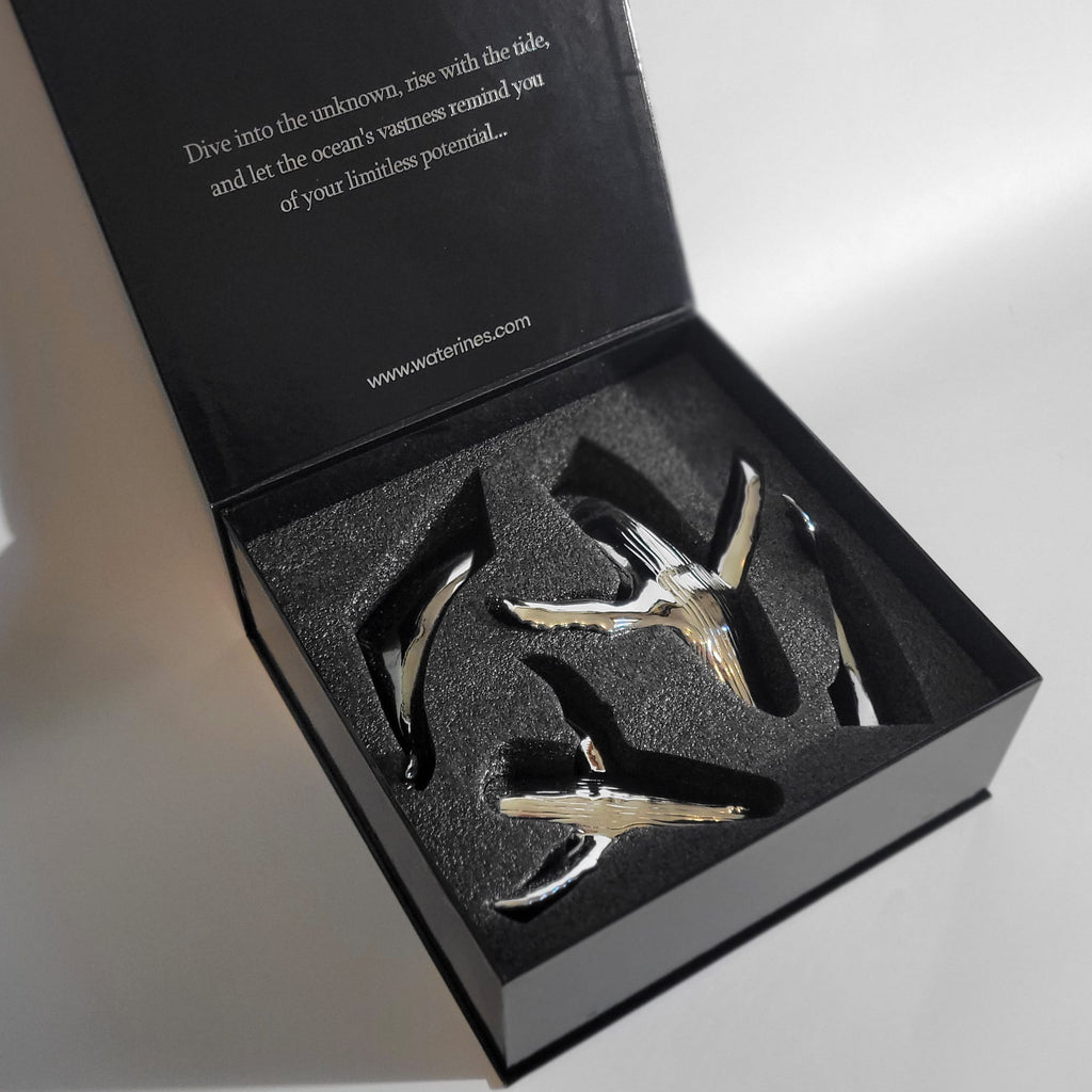 Euphoria Whale Set by Waterines — 3D sculpted magnetic resin whale sculptures breach through a glass coffee table.
