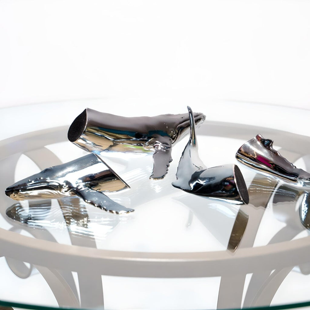 Euphoria Whale Set by Waterines — 3D sculpted magnetic resin whale sculptures breach through a glass coffee table.